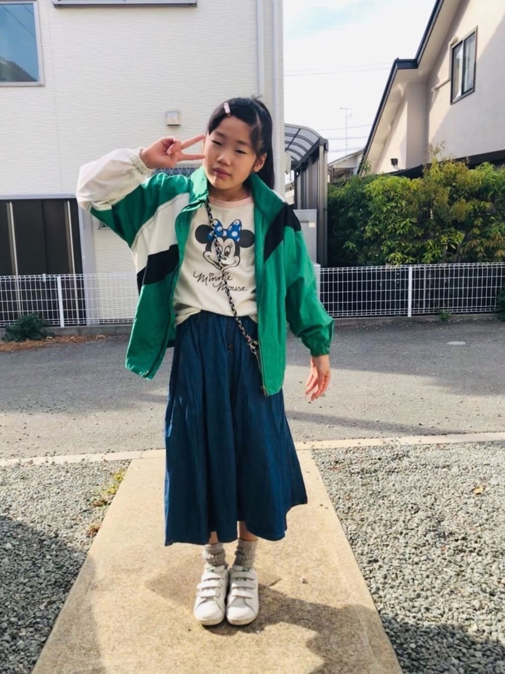 ピンク系のTシャツ/カットソー、ブルー系のスカート、ホワイト系のスニーカーを着用したキッズの春コーディネートの1枚目の写真
