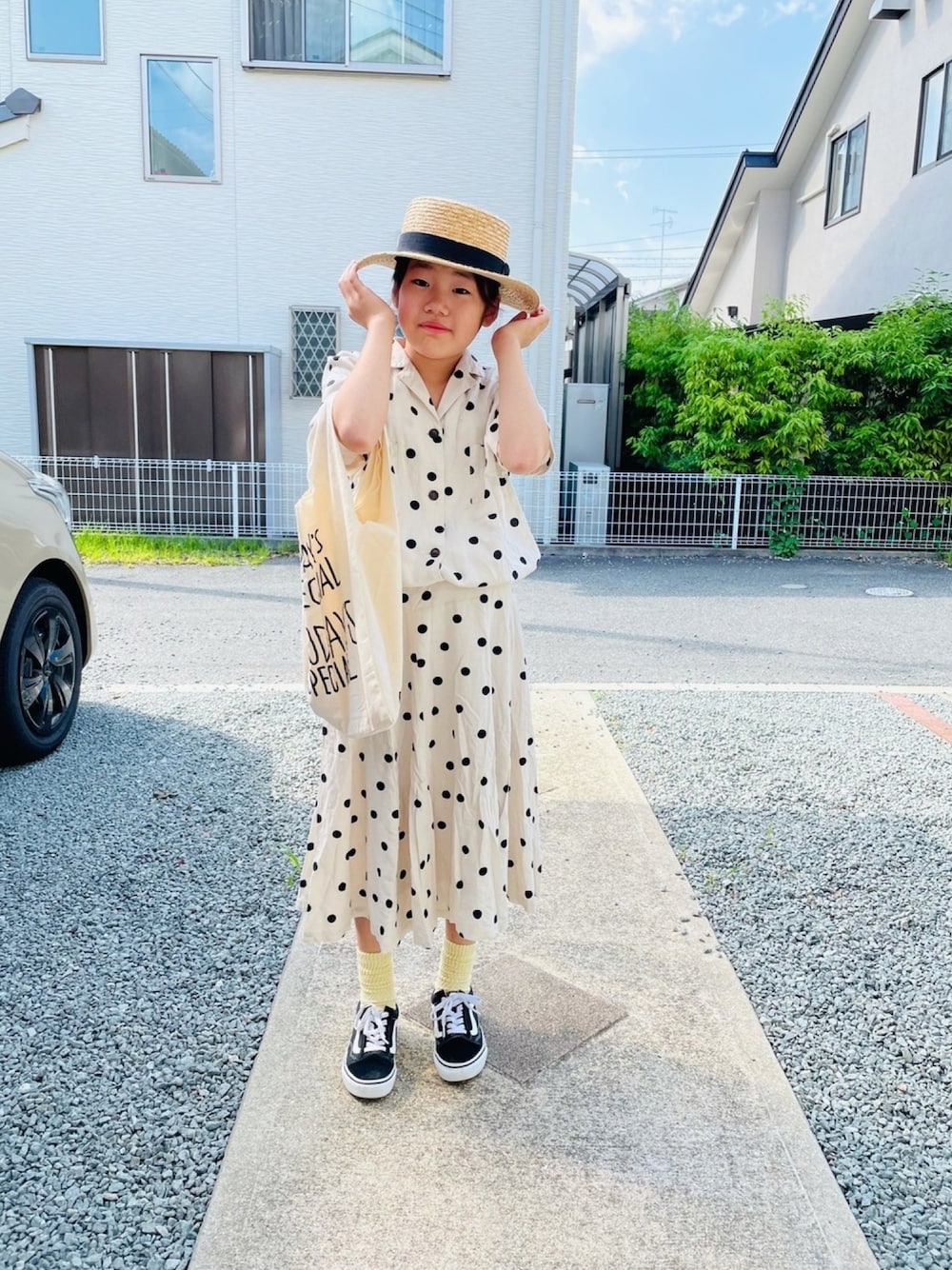 ホワイト系のシャツ/ブラウス、ホワイト系のスカート、ブラック系のスニーカーを着用したキッズの春コーディネートの1枚目の写真