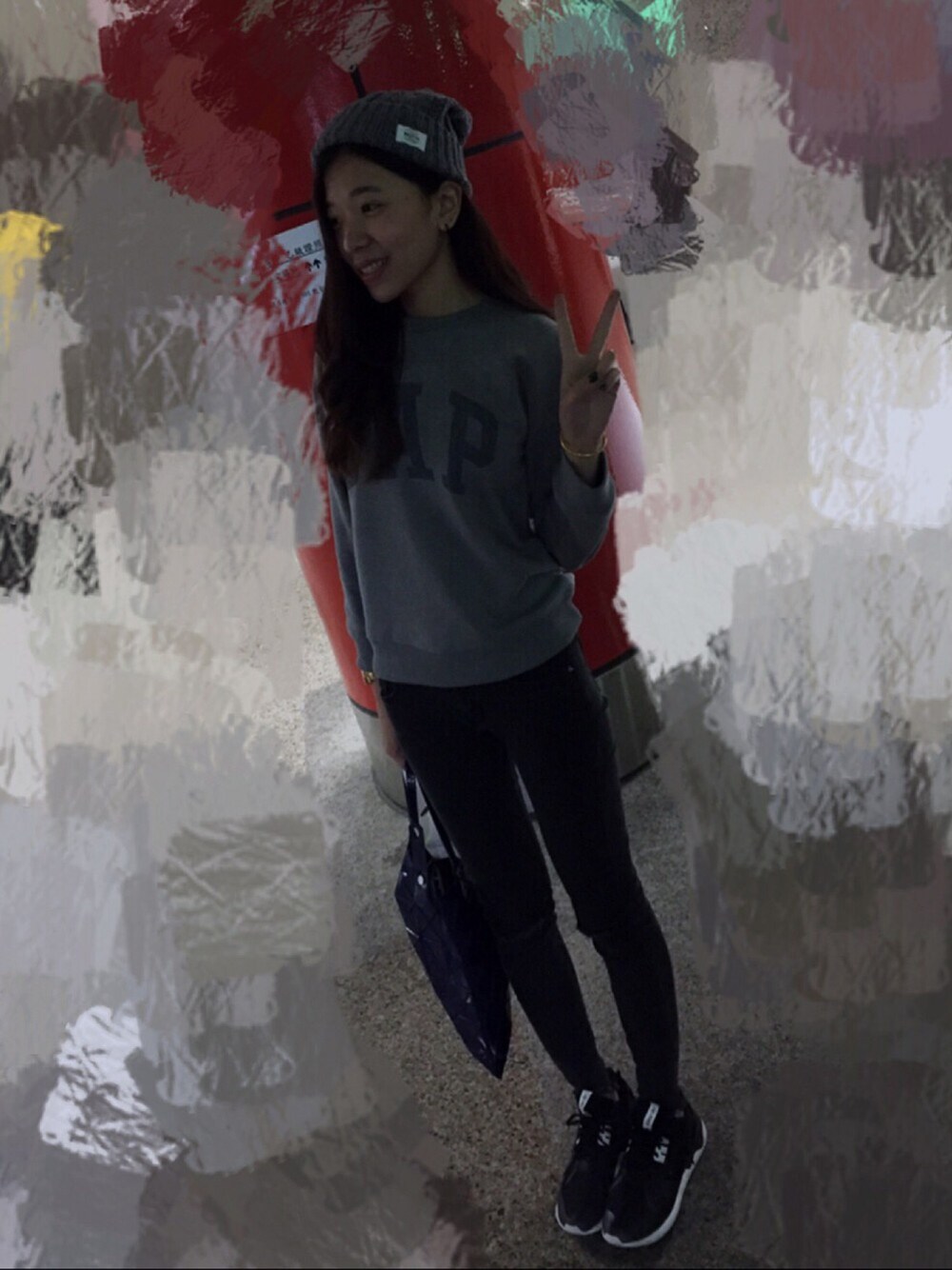 グレー系のトップス、グレー系のトートバッグ、ブラック系のスニーカーを着用したレディースの冬コーディネートの1枚目の写真