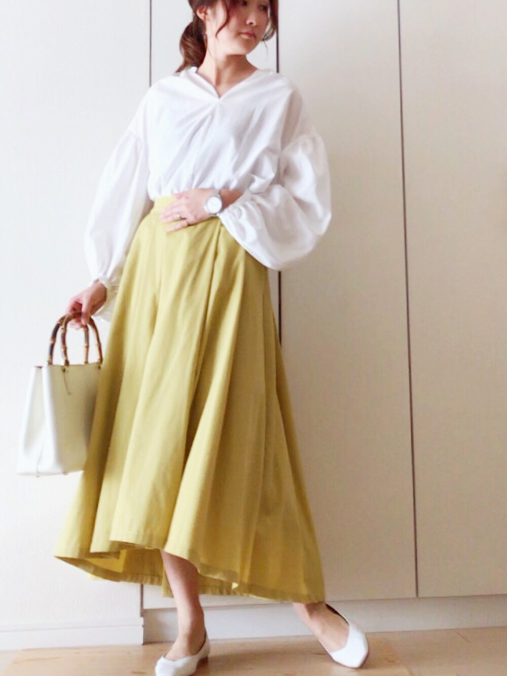 ホワイト系のシャツ/ブラウス、イエロー系のスカート、ホワイト系のトートバッグを着用したレディースの春コーディネートの1枚目の写真