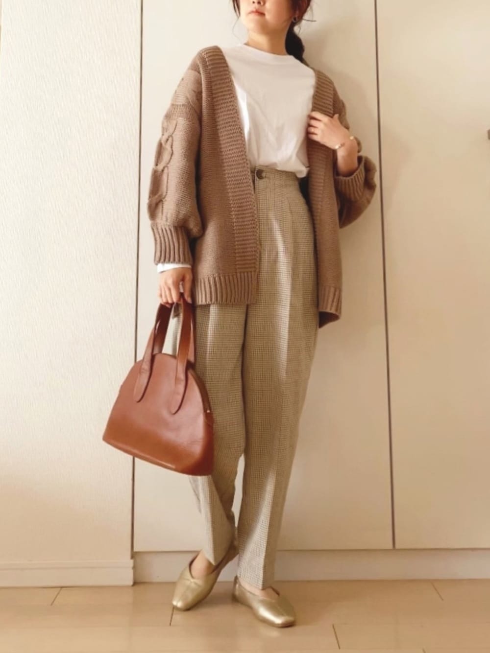 ホワイト系のTシャツ/カットソー、ベージュ系のカーディガン/ボレロ、ゴールド系のパンプスを着用したレディースの冬コーディネートの1枚目の写真