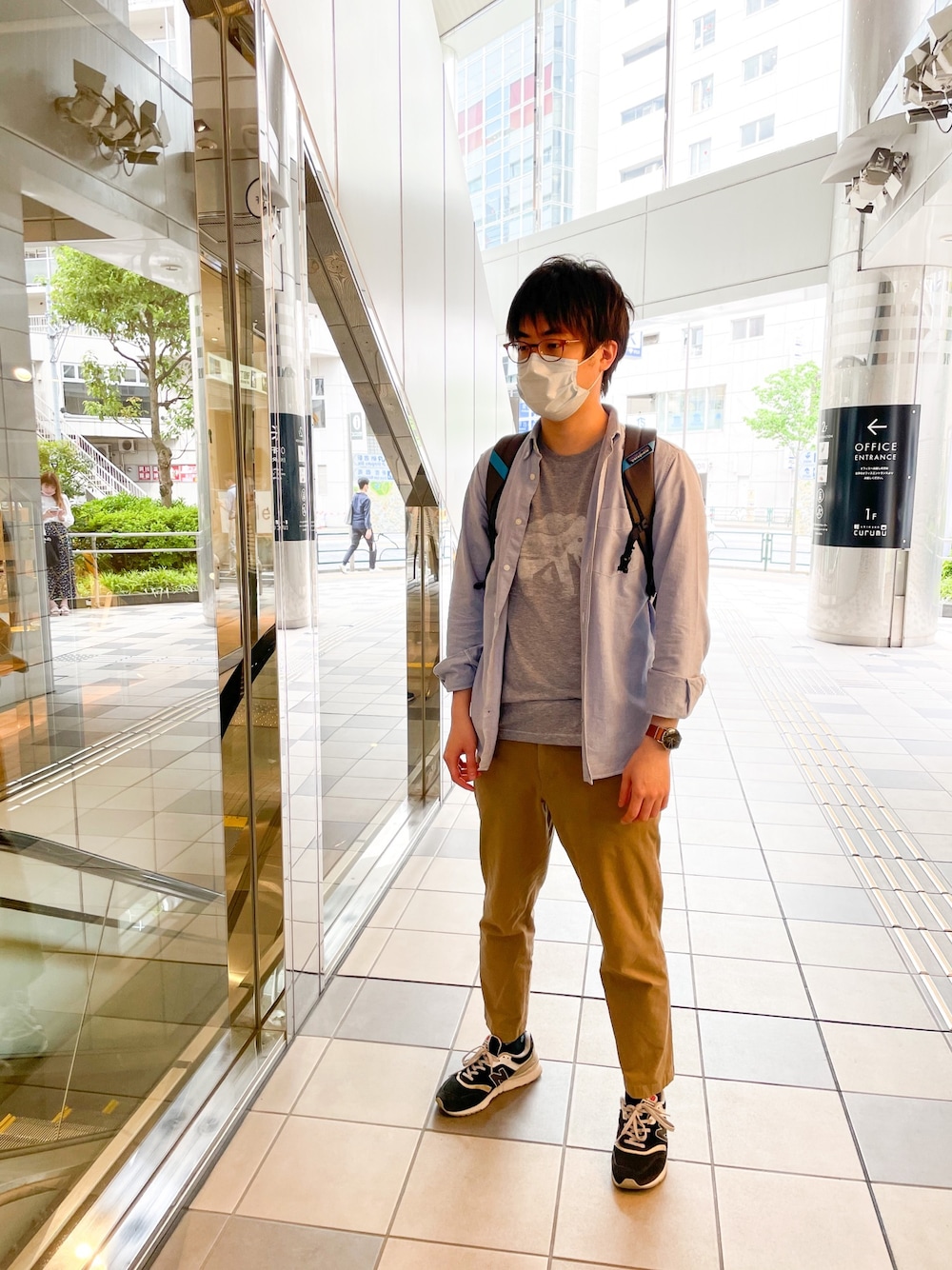 ブルー系のバックパック/リュック、グレー系のTシャツ/カットソー、ブルー系のシャツ/ブラウスを着用したメンズの春コーディネートの1枚目の写真