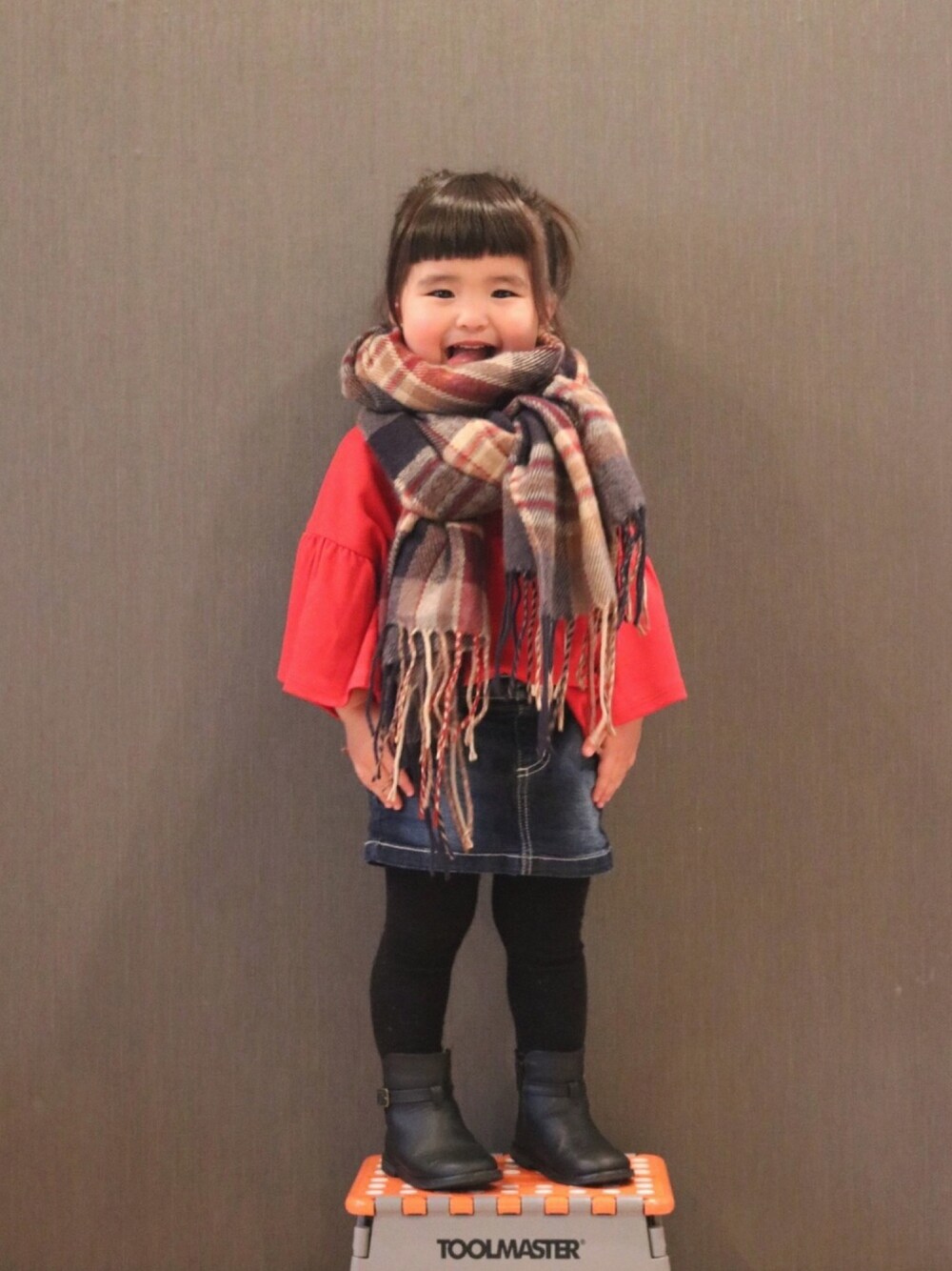 「赤、ゆるトップス、デニムスカート、ミニスカート、ブーツ、チェックマフラー、2歳」｜「UNIQLOのアイテム（Tシャツ/カットソー、レッド系）」を使った、SuzuMinaさん（キッズ・90cm）の秋コーディネートの1枚目の写真