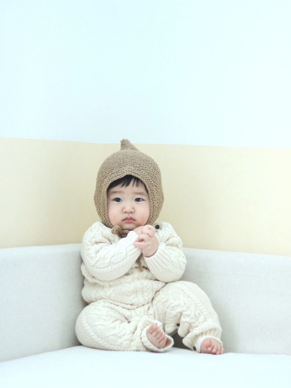 「ニットロンパース、ケーブルニット、ボンネット、赤ちゃん、ベビーコーデ」｜「B:MING by BEAMSのB:MING by BEAMS / 手編 ボンネット（ニットキャップ/ビーニー、ベージュ系）」を使った、SuzuMinaさん（キッズ・110cm）の冬コーディネートの1枚目の写真