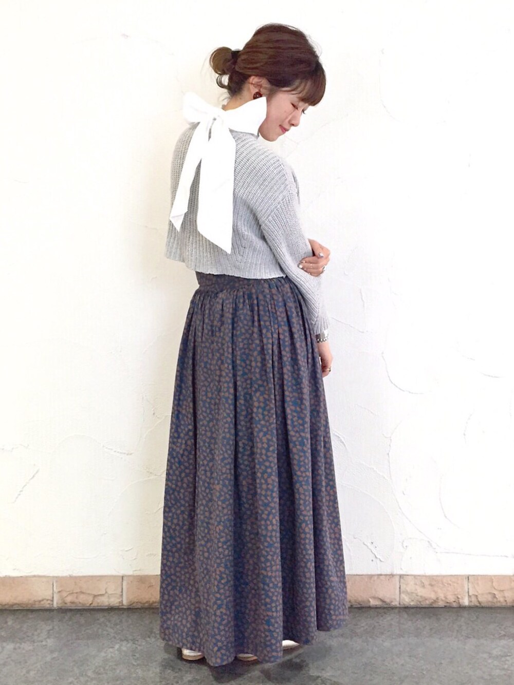 ブルー系のスカート、グレー系のニット/セーター、ホワイト系のシャツ/ブラウスを着用したレディースの冬コーディネートの1枚目の写真