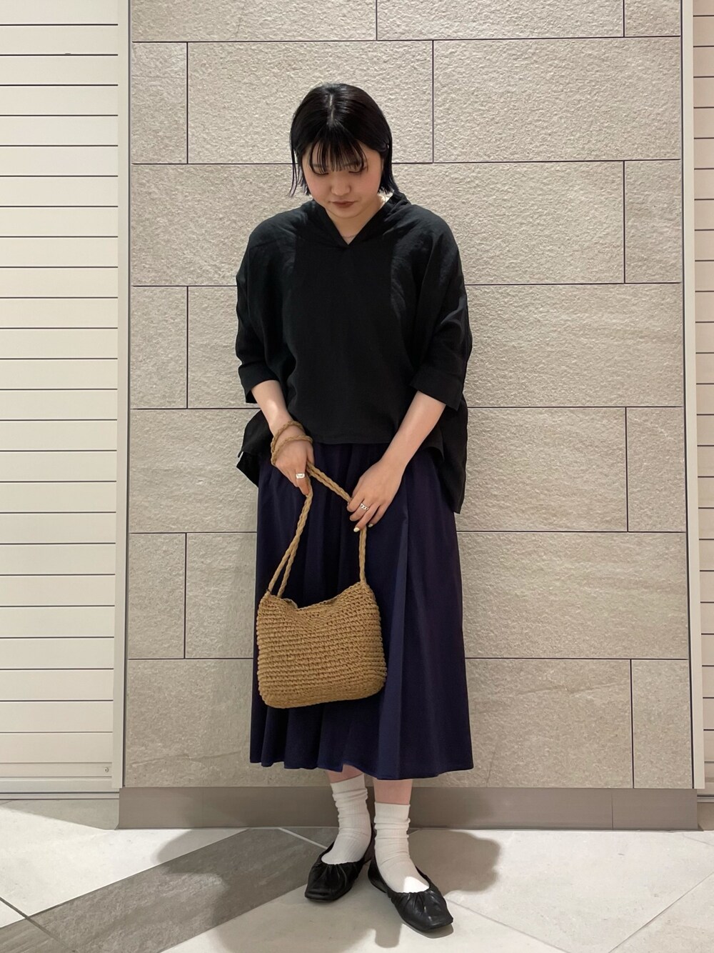 ブラック系のシャツ/ブラウス、ブルー系のスカート、ベージュ系のショルダーバッグを着用したレディースの春コーディネートの1枚目の写真