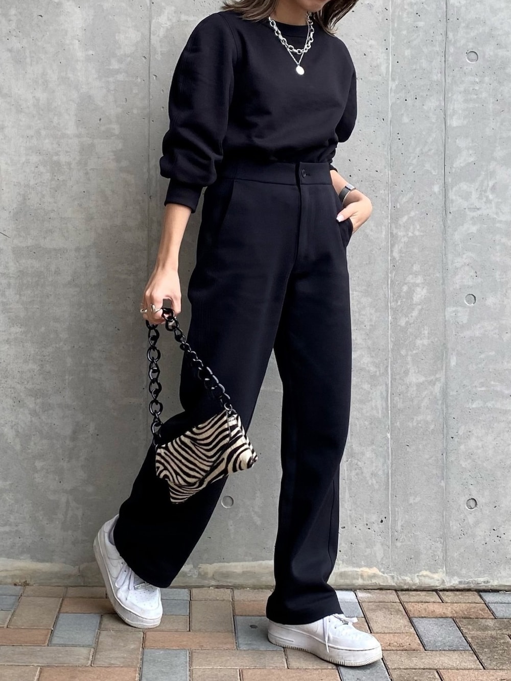 ブラック系のスウェット、ブラック系のその他パンツ、ホワイト系のスニーカーを着用したレディースの冬コーディネートの1枚目の写真