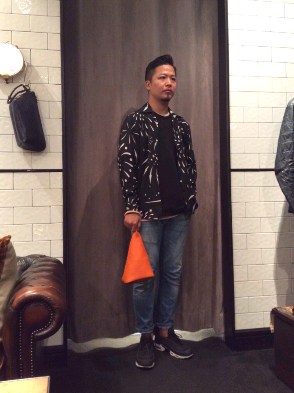 オレンジ系のハンドバッグを着用したメンズの春コーディネートの1枚目の写真