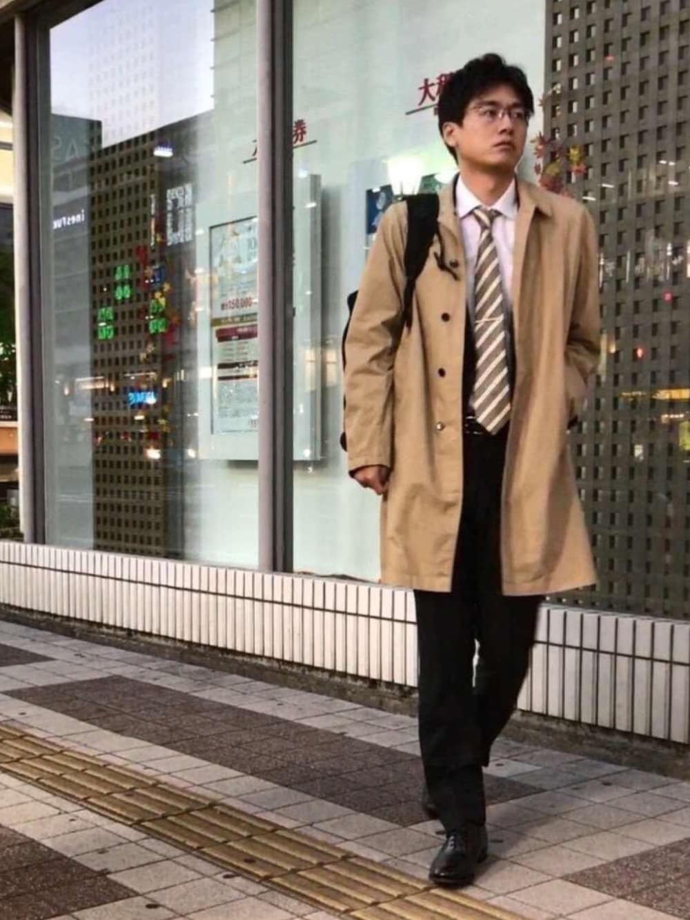 「秋のコーデ、スーツスタイル、コート、ステンカラーコート、ネクタイ、革靴、ブラック、ベージュ、リュック、ビジネススタイル」｜「STILL BY HANDのアイテム（ステンカラーコート、ベージュ系）」を使った、ダイスさん（メンズ・185cm）の秋コーディネートの1枚目の写真