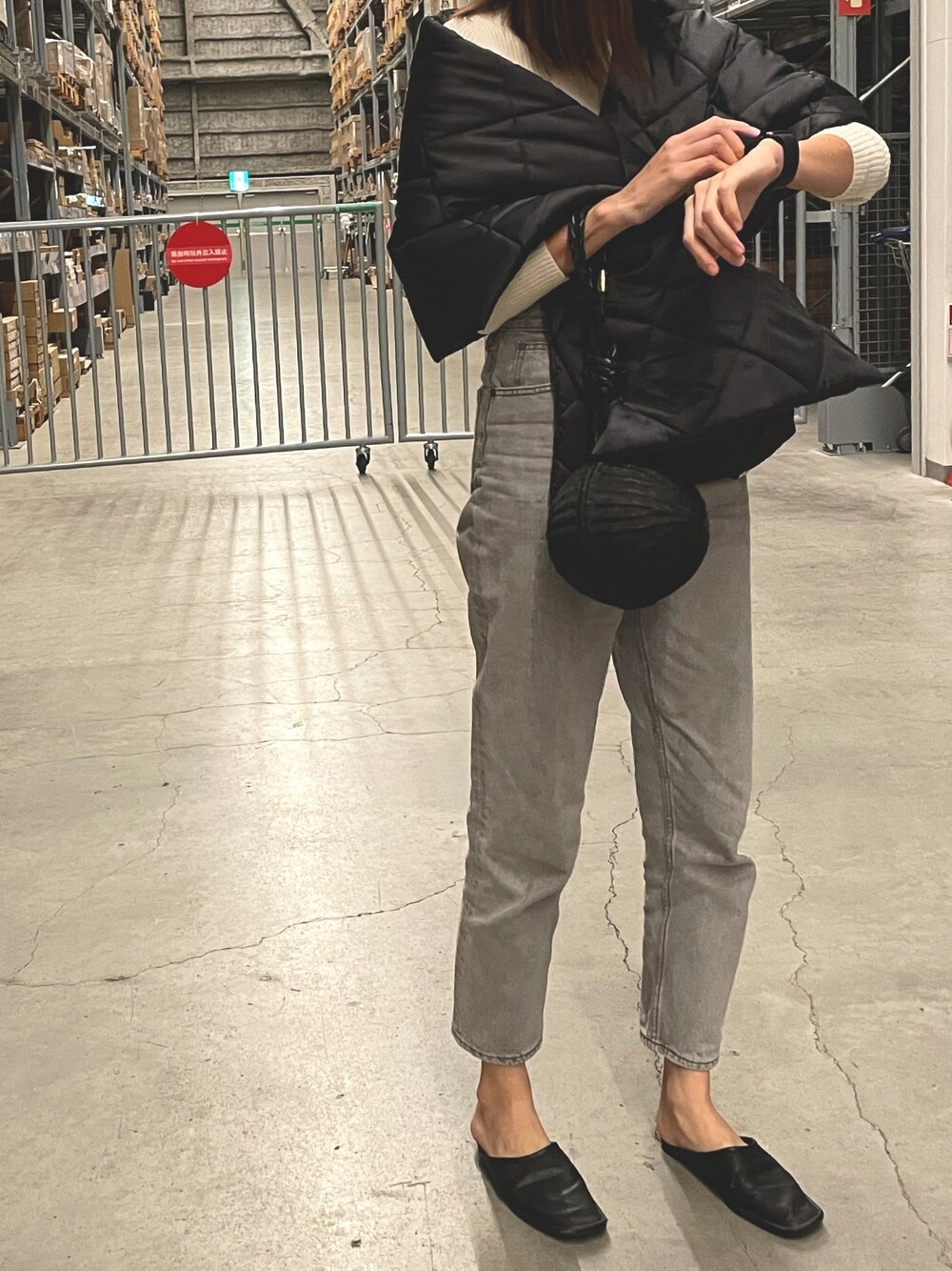 ホワイト系のニット/セーター、グレー系のデニムパンツ、ブラック系のサンダルを着用したレディースの冬コーディネートの1枚目の写真