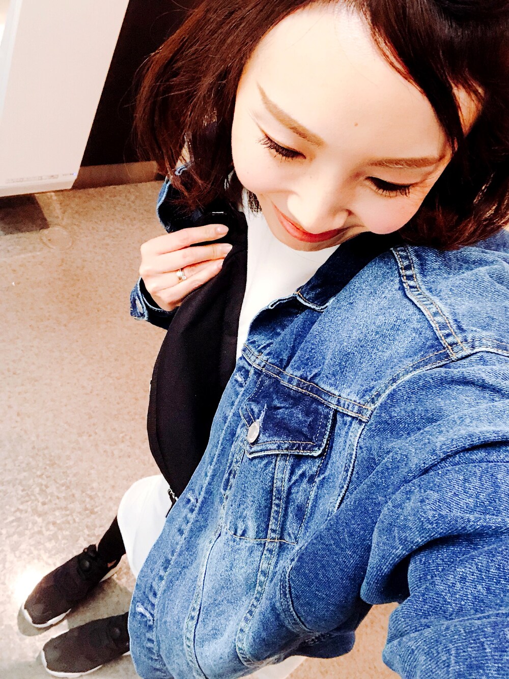 ブルー系のデニムジャケット、ブラック系のショルダーバッグ、ブラック系のスニーカーを着用したレディースの春コーディネートの1枚目の写真