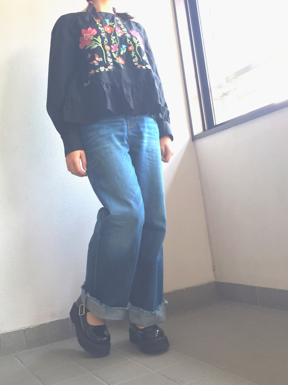 ブルー系のパンツ、ブラック系のバッグ、ブラック系のシューズを着用したレディースの春コーディネートの1枚目の写真