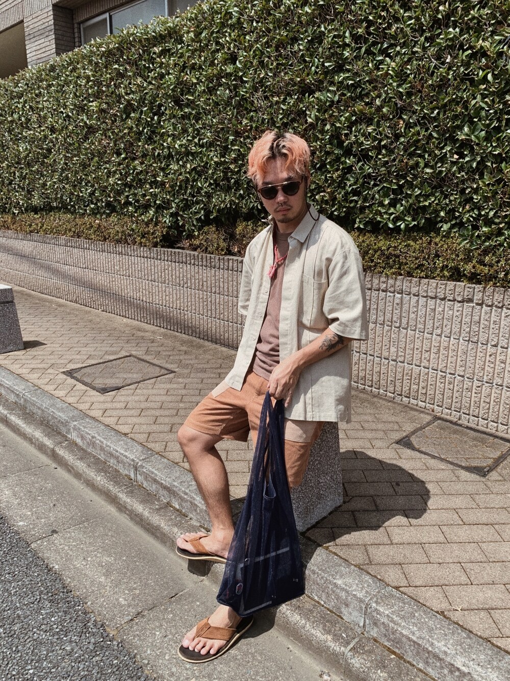 ブラウン系のパンツ、ブルー系のエコバッグ/サブバッグ、ブラウン系のサンダルを着用したメンズの夏コーディネートの1枚目の写真