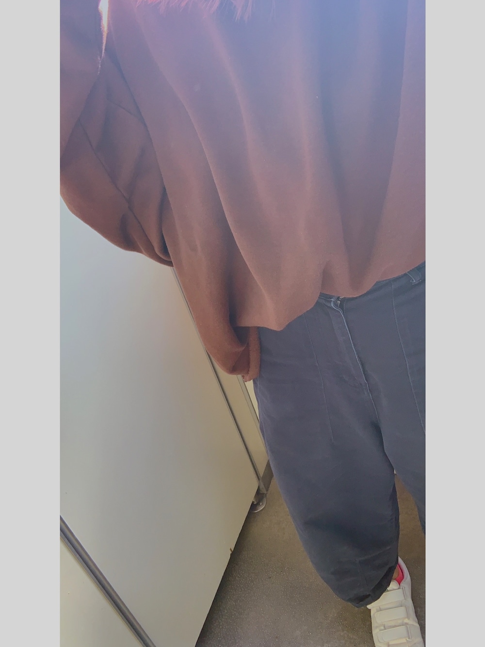 ブラウン系のスウェット、ブルー系のチノパンツ、グリーン系のスニーカーを着用したレディースの冬コーディネートの1枚目の写真