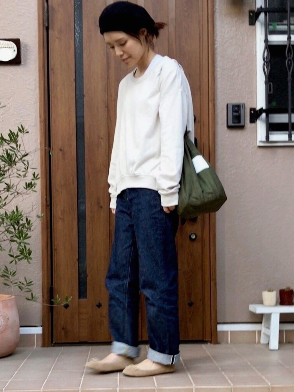 ベージュ系のスウェット、ブルー系のデニムパンツ、ベージュ系のバレエシューズを着用したレディースの秋コーディネートの1枚目の写真