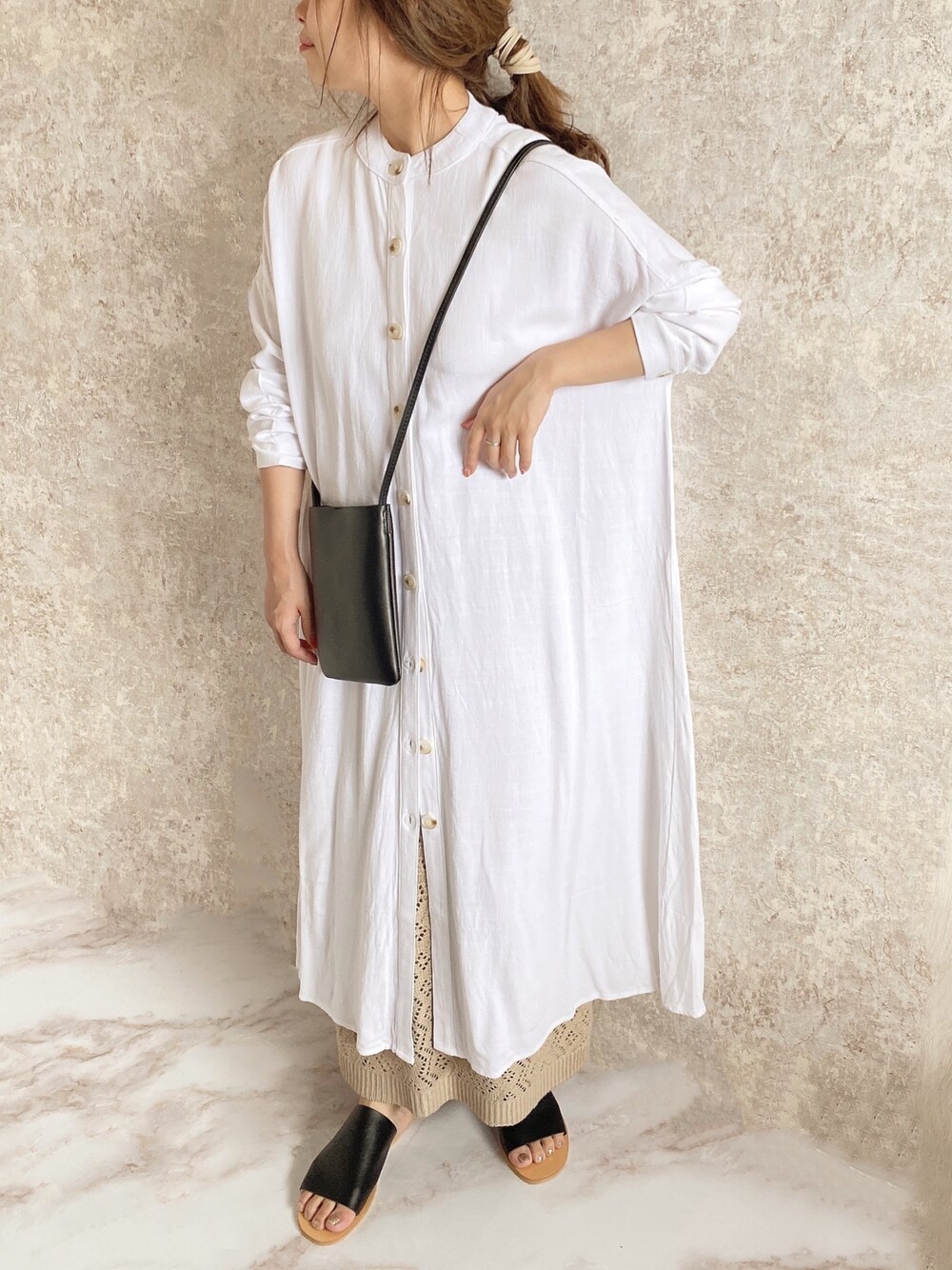 ホワイト系のワンピース、ブラック系のショルダーバッグ、ベージュ系のスカートを着用したレディースの夏コーディネートの1枚目の写真