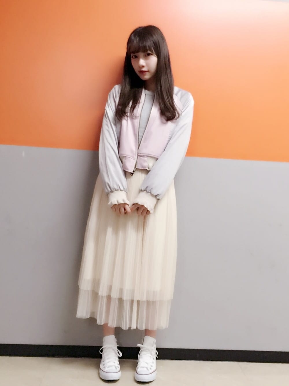 ピンク系のジャケット/アウター、グレー系のニット/セーター、ホワイト系のスニーカーを着用したレディースの春コーディネートの1枚目の写真