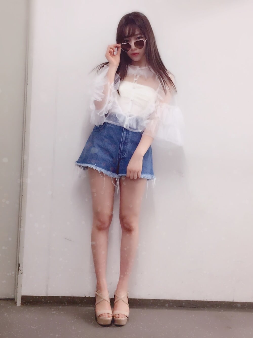 ホワイト系のトップス、ブルー系のデニムパンツ、ベージュ系のサンダルを着用したレディースの春コーディネートの1枚目の写真