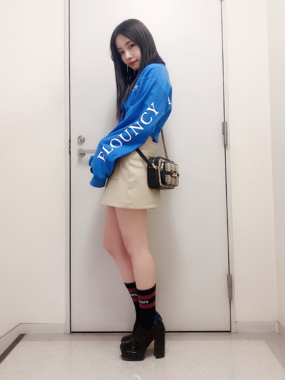 ブルー系のTシャツ/カットソー、ベージュ系のスカート、ブラック系のブーツを着用したレディースの春コーディネートの1枚目の写真