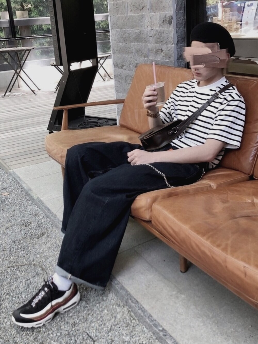 ブルー系のデニムパンツ、ブラック系のTシャツ/カットソー、ブラック系のスニーカーを着用したメンズの春コーディネートの1枚目の写真