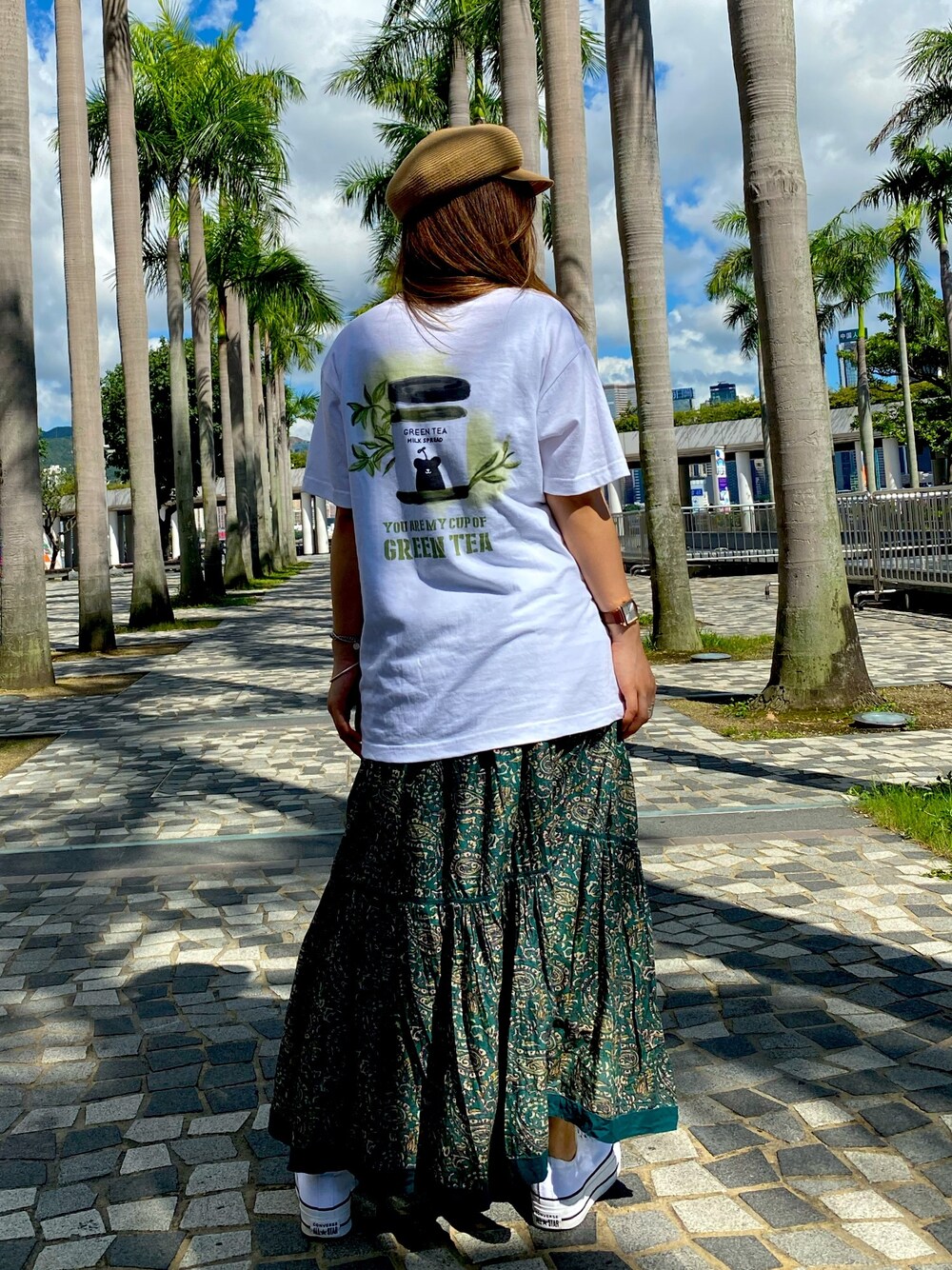 ホワイト系のTシャツ/カットソー、グリーン系のスカート、ホワイト系のスニーカーを着用したレディースの夏コーディネートの1枚目の写真