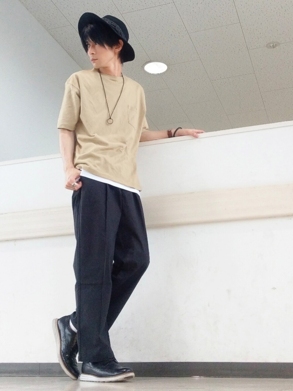 ブラック系のチノパンツ、ベージュ系のTシャツ/カットソー、ブラック系のドレスシューズを着用したメンズの夏コーディネートの1枚目の写真