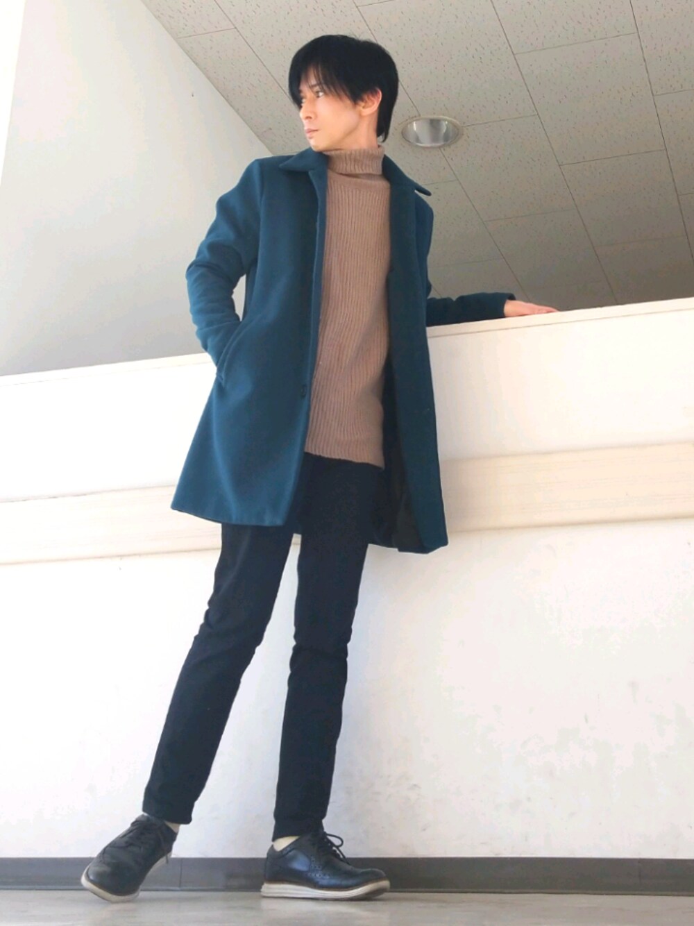 ブラック系のデニムパンツ、ブラック系のドレスシューズ、ブルー系のステンカラーコートを着用したメンズの秋コーディネートの1枚目の写真