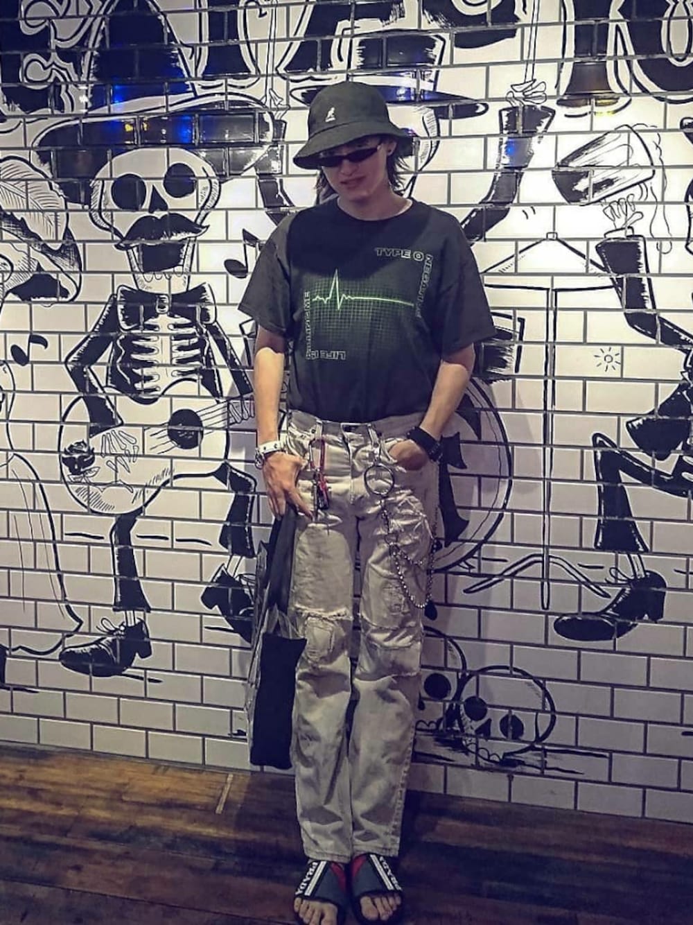 「バンドT、メタル、シャワーサンダル、PRADA、タックイン、ウォレットチェーン、Levi's、モノトーン、バケットハット」｜「00sのアイテム（Tシャツ/カットソー、ブラック系）」を使った、やんねさん（メンズ・180cm）の夏コーディネートの1枚目の写真