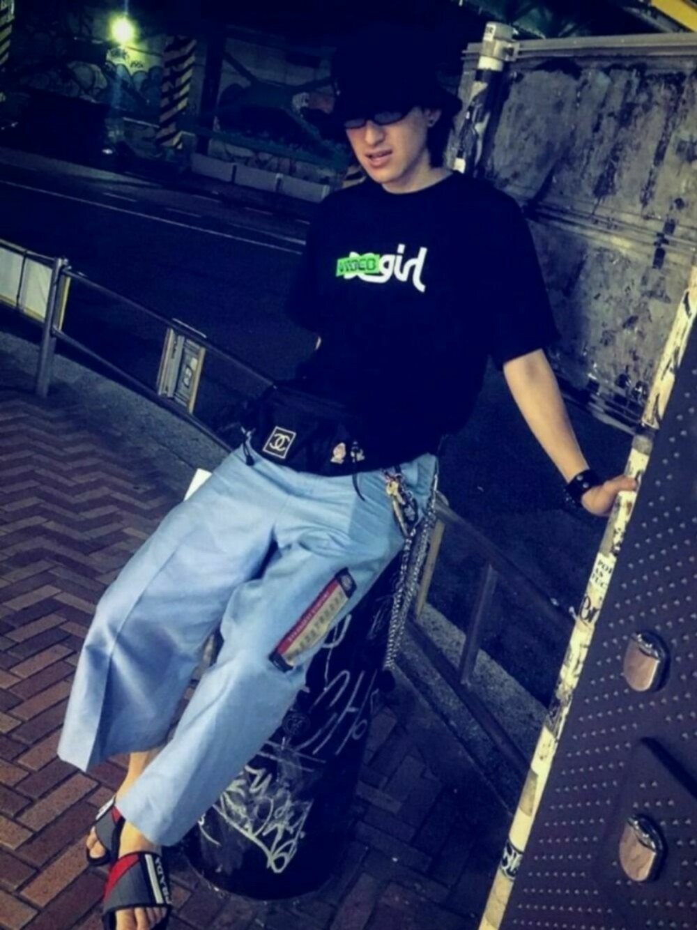 「doublet、バケットハット、x-girl、シャネル、chanel、プラダ、PRADA、シャワーサンダル、ロゴT、ウエストポーチ」｜「X-girlのX-girl x VIDEO GIRL NOISE S/S MENS TEE（Tシャツ/カットソー、ブラック系）」を使った、やんねさん（メンズ・180cm）の夏コーディネートの1枚目の写真