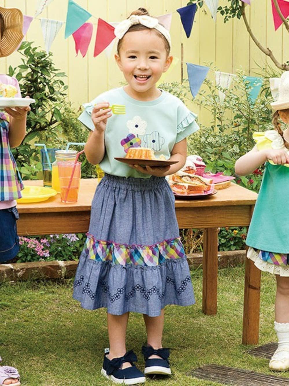 グリーン系のTシャツ/カットソー、ブルー系のスカート、ブルー系のドレスシューズを着用したキッズの春コーディネートの1枚目の写真