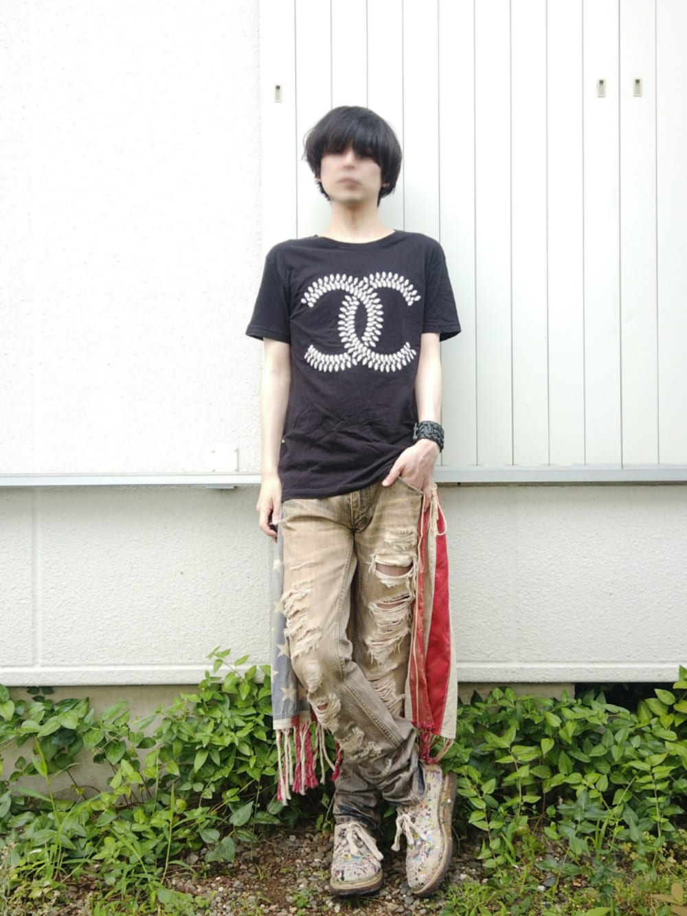 ブラック系のTシャツ/カットソー、レッド系のポンチョ、ベージュ系のデニムパンツを着用したメンズの夏コーディネートの1枚目の写真