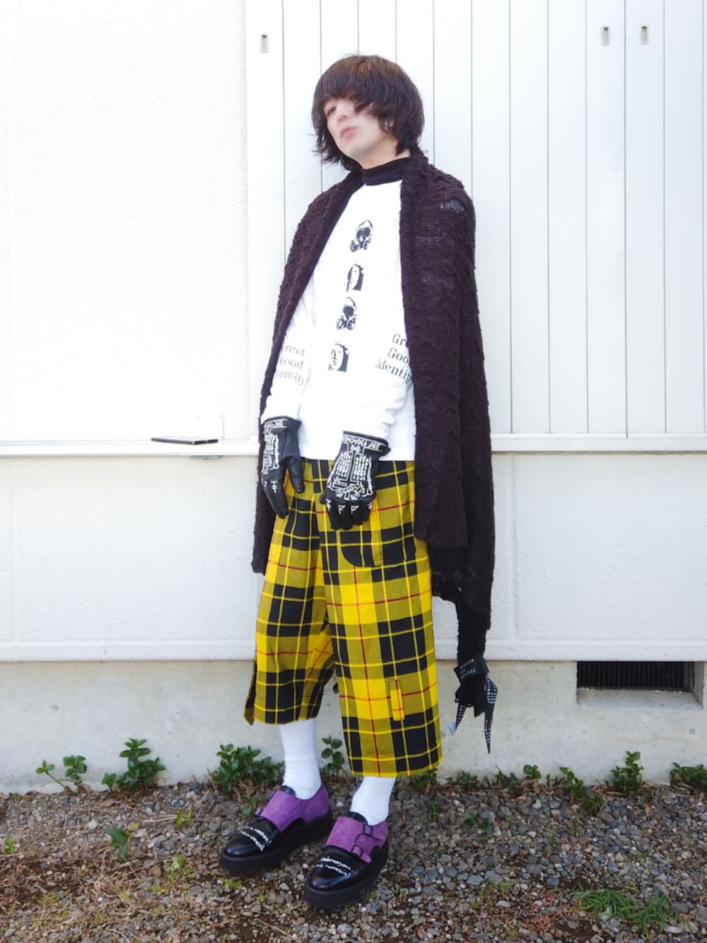 ホワイト系のTシャツ/カットソー、ブラック系のニット/セーター、イエロー系のパンツを着用したメンズの冬コーディネートの1枚目の写真