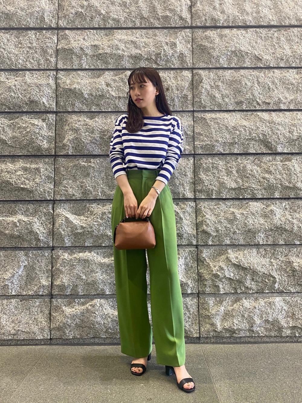 ブルー系のTシャツ/カットソー、グリーン系のその他パンツ、ブラウン系のショルダーバッグを着用したレディースの春コーディネートの1枚目の写真