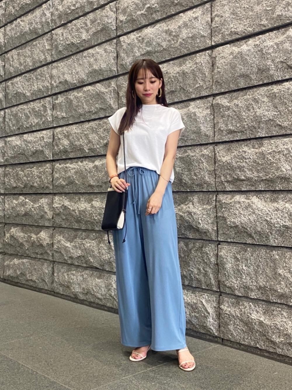 ブラック系のショルダーバッグ、ベージュ系のサンダル、ホワイト系のニット/セーターを着用したレディースの夏コーディネートの1枚目の写真