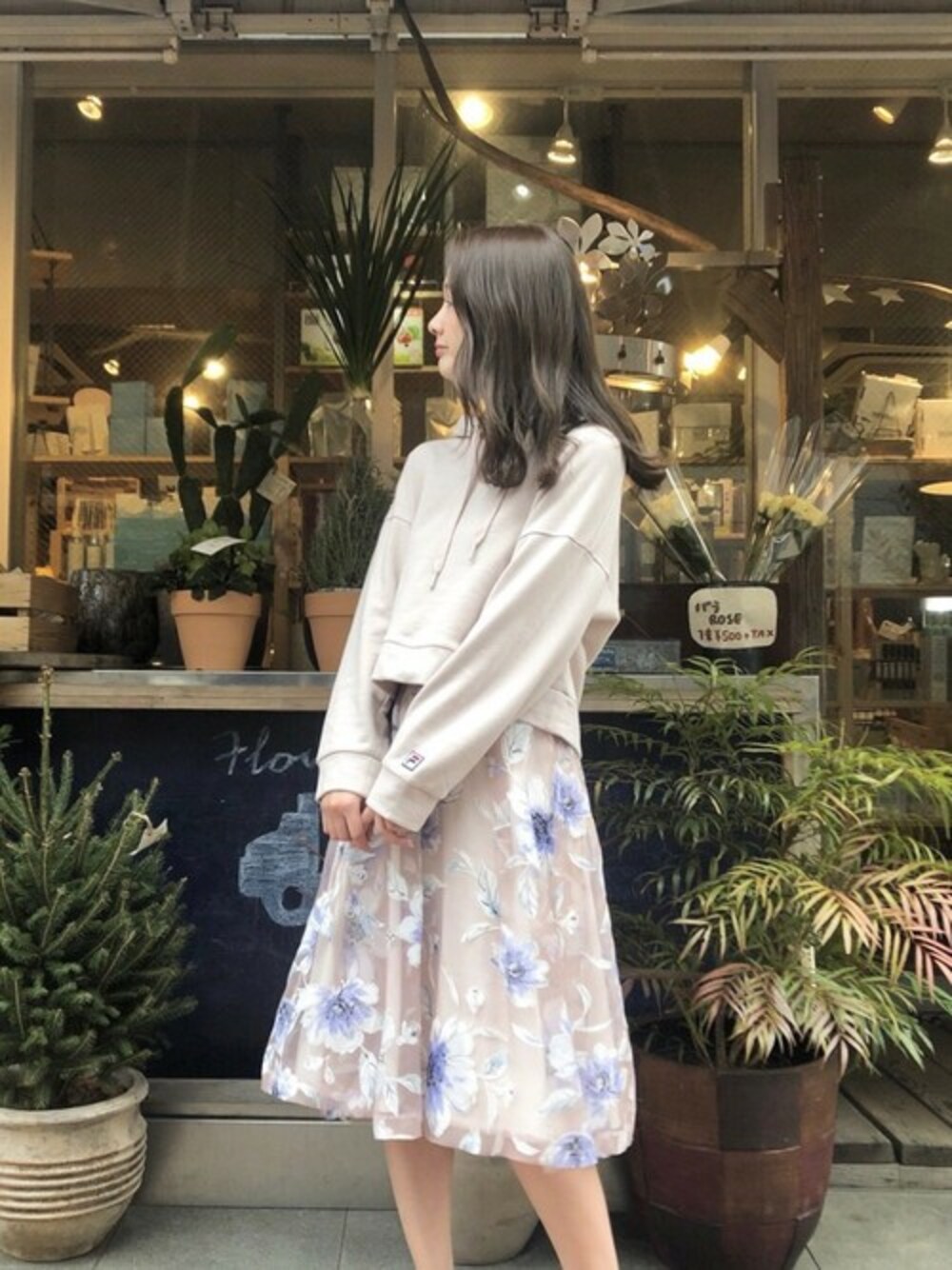 「パーカー、スポーツミックス、FILA、カジュアルミックス、花柄スカート、MERCURYDUO(MERCURYDUO)、パーカーコーデ、カジュアルフェミニン、FILA×MERCURYDUO」｜「MERCURYDUOの【FILA×MERCURYDUO】裏毛パーカー（パーカー、ベージュ系）」を使った、長澤 実果さん（レディース・160cm）の冬コーディネートの1枚目の写真