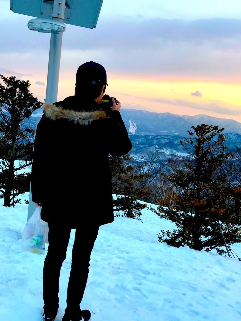 ブラック系のダウンジャケット/コート、ブラック系のデニムパンツ、ホワイト系のスニーカーを着用したメンズの秋コーディネートの1枚目の写真