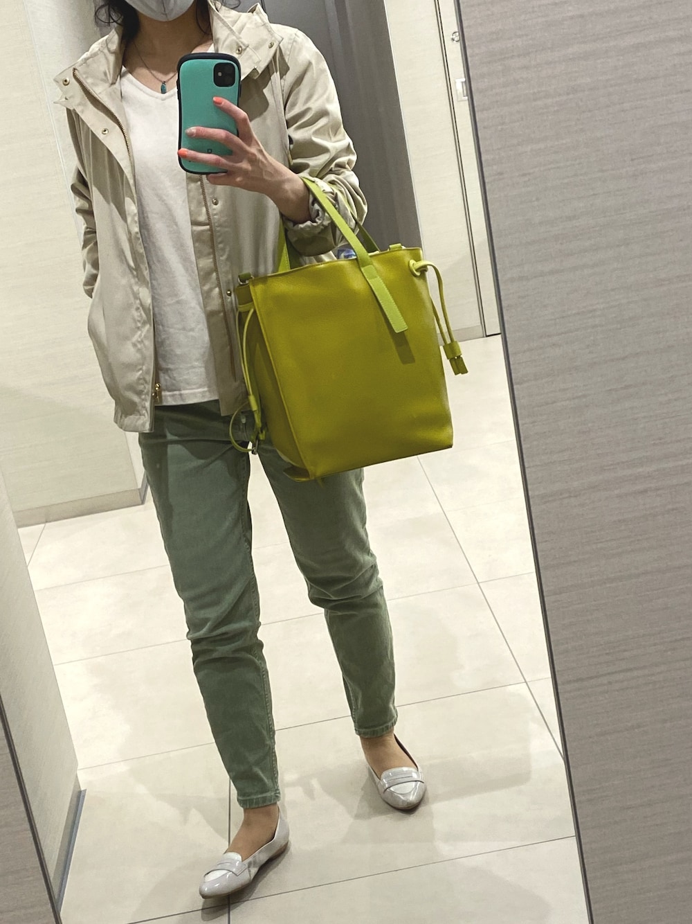 イエロー系のバッグ、グリーン系のパンツ、ブラック系のバレエシューズを着用したレディースの春コーディネートの1枚目の写真