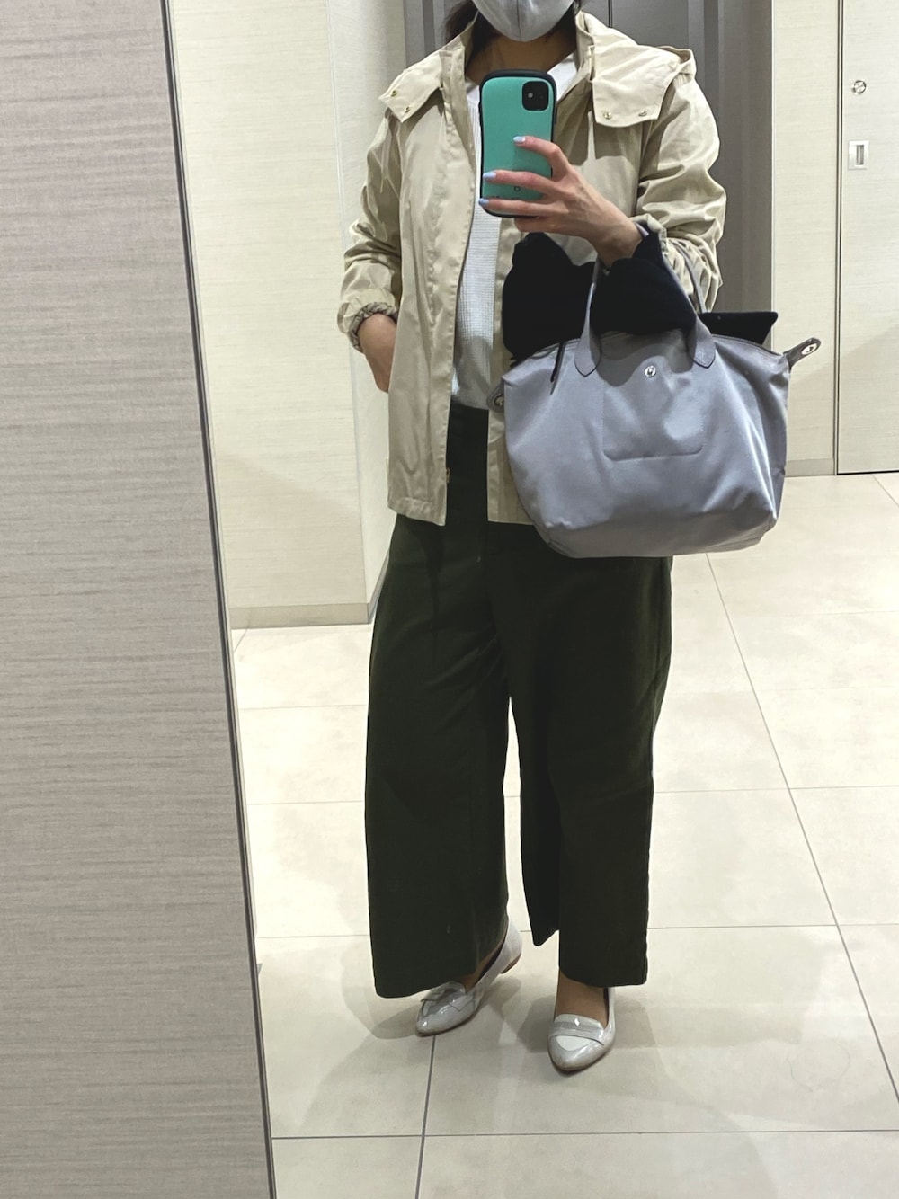 グリーン系のパンツ、ブラック系のバレエシューズ、シルバー系のトートバッグを着用したレディースの春コーディネートの1枚目の写真