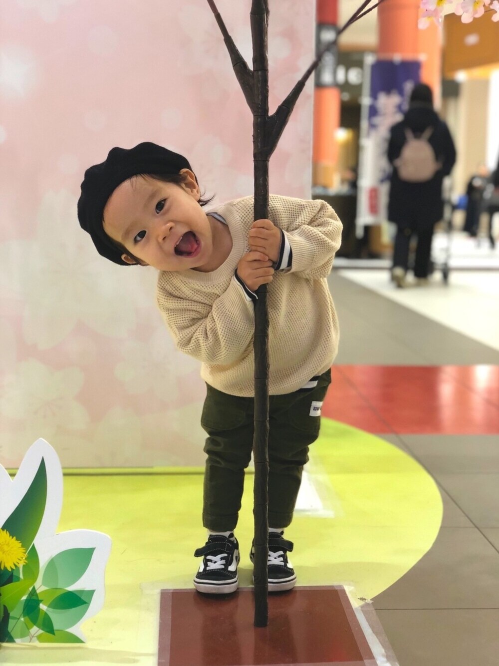 ベージュ系のニット/セーター、グリーン系のパンツ、ブラック系のスニーカーを着用したキッズの春コーディネートの1枚目の写真