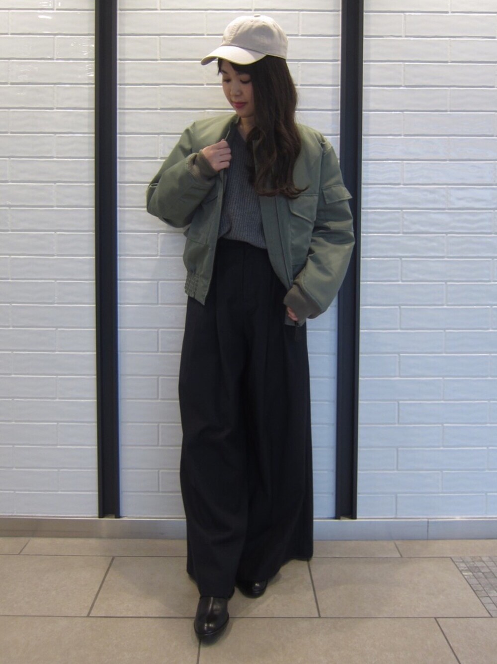 グリーン系のミリタリージャケット、ブルー系のその他パンツ、グレー系のニット/セーターを着用したレディースの冬コーディネートの1枚目の写真