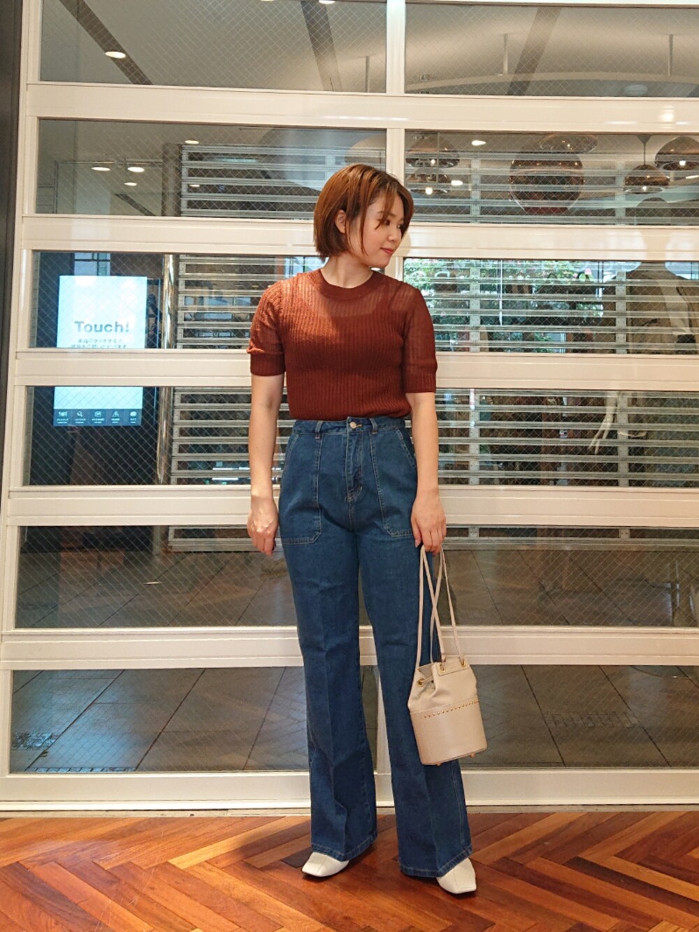 ブルー系のデニムパンツ、ホワイト系のショルダーバッグを着用したレディースの春コーディネートの1枚目の写真