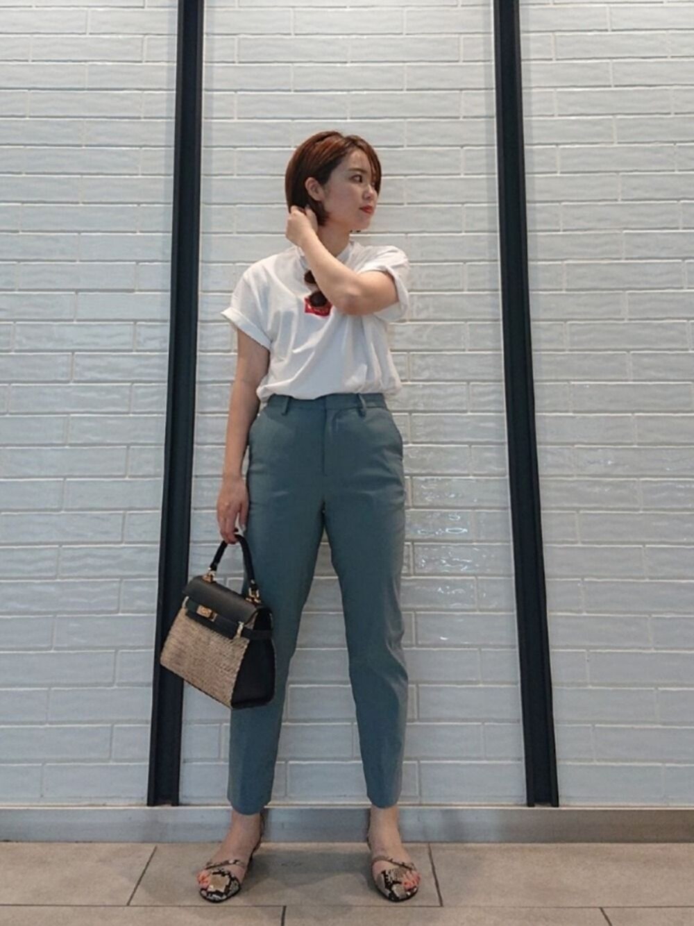 グリーン系のその他パンツ、ホワイト系のトップス、ブルー系のハンドバッグを着用したレディースの春コーディネートの1枚目の写真