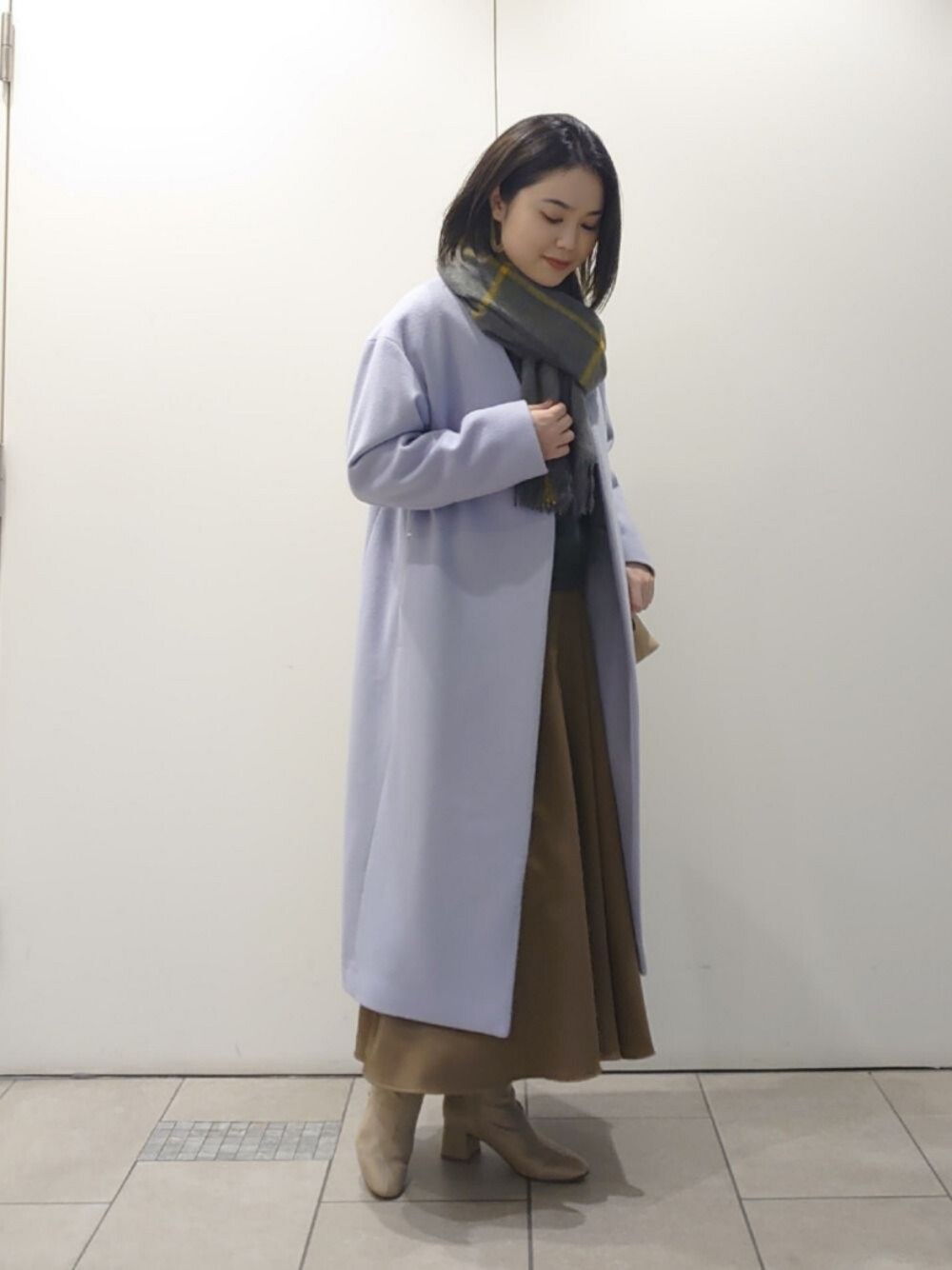 ブラウン系のスカート、ブルー系のその他アウター、ベージュ系のブーツを着用したレディースの冬コーディネートの1枚目の写真