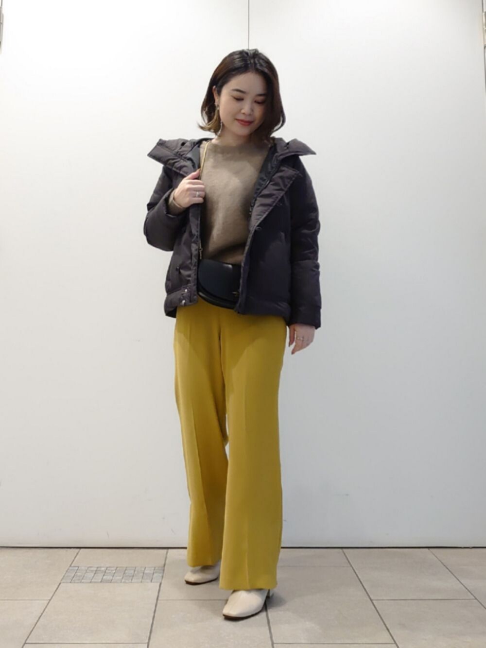 イエロー系のその他パンツ、ベージュ系のブーツ、イエロー系のカーディガン/ボレロを着用したレディースの冬コーディネートの1枚目の写真