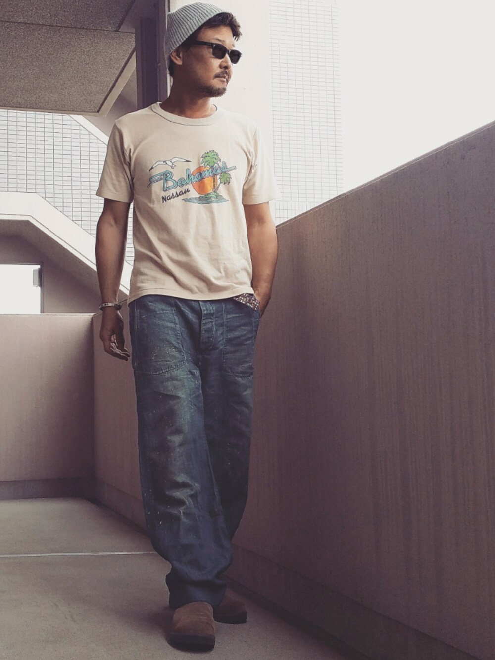 ベージュ系のTシャツ/カットソー、ブルー系のデニムパンツ、ブラウン系のブーツを着用したメンズの夏コーディネートの1枚目の写真