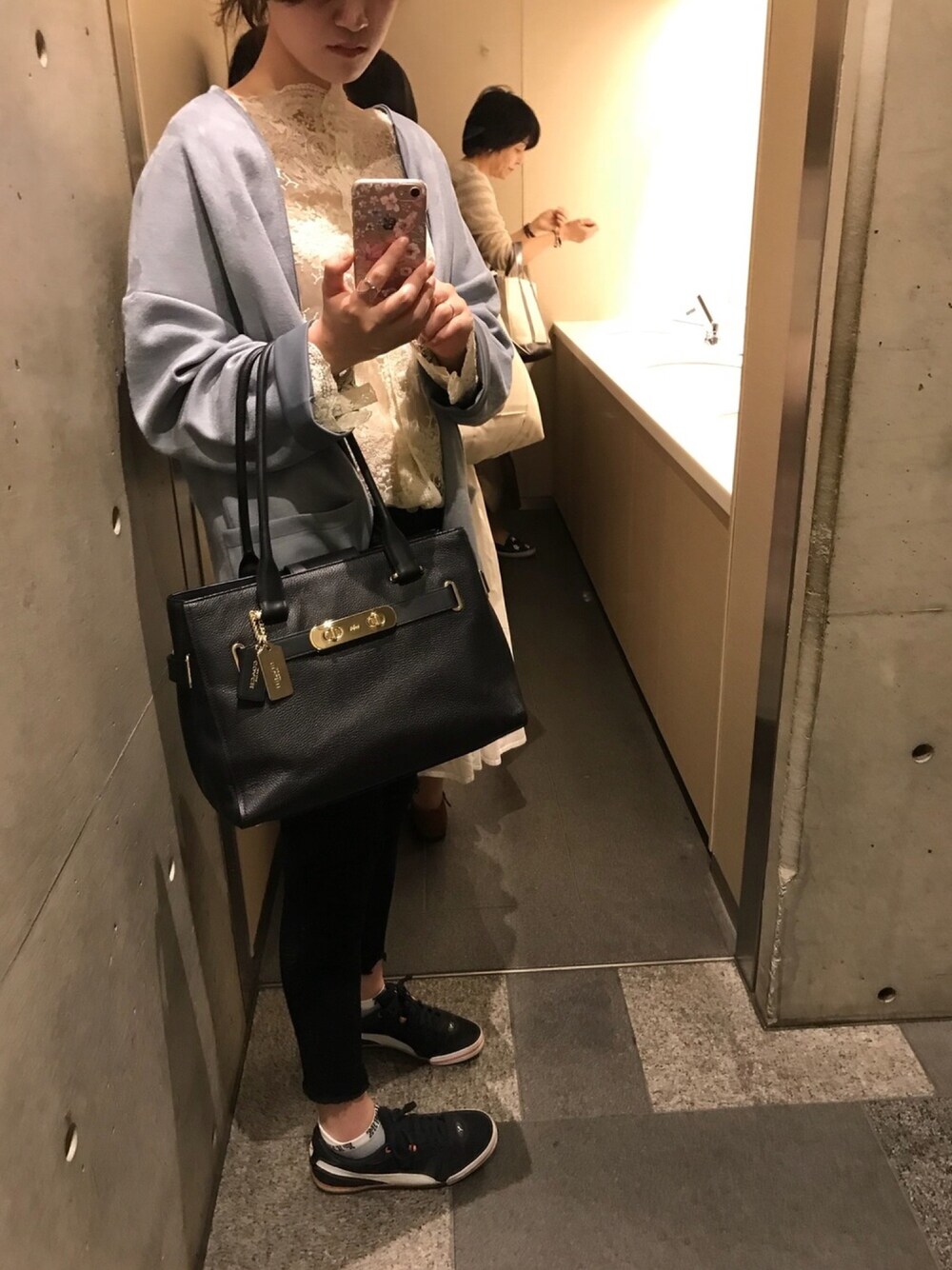 ブラック系のハンドバッグ、ブラック系のデニムパンツ、ブルー系のジャケット/アウターを着用したレディースの春コーディネートの1枚目の写真