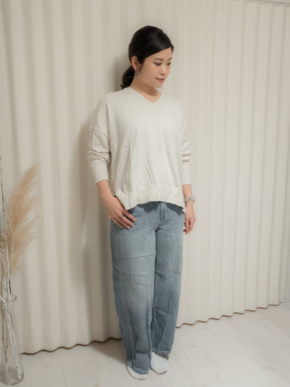 ホワイト系のニット/セーター、ブルー系のデニムパンツ、ホワイト系のアナログ腕時計を着用したレディースの冬コーディネートの1枚目の写真