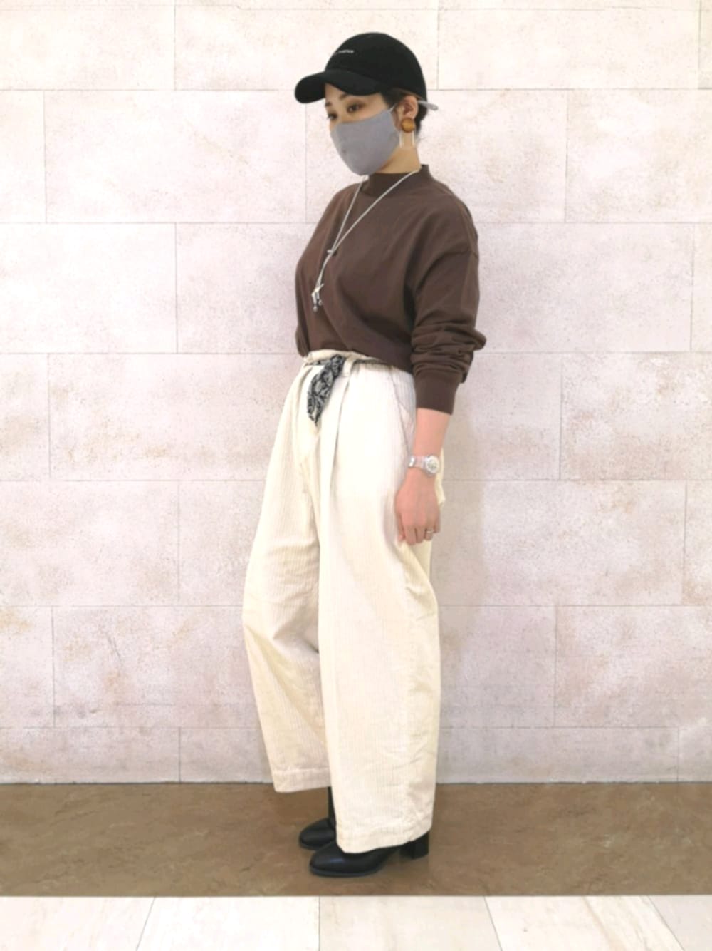 ホワイト系のその他パンツ、ブラック系のシューズ、ブラウン系のニット/セーターを着用したレディースの冬コーディネートの1枚目の写真