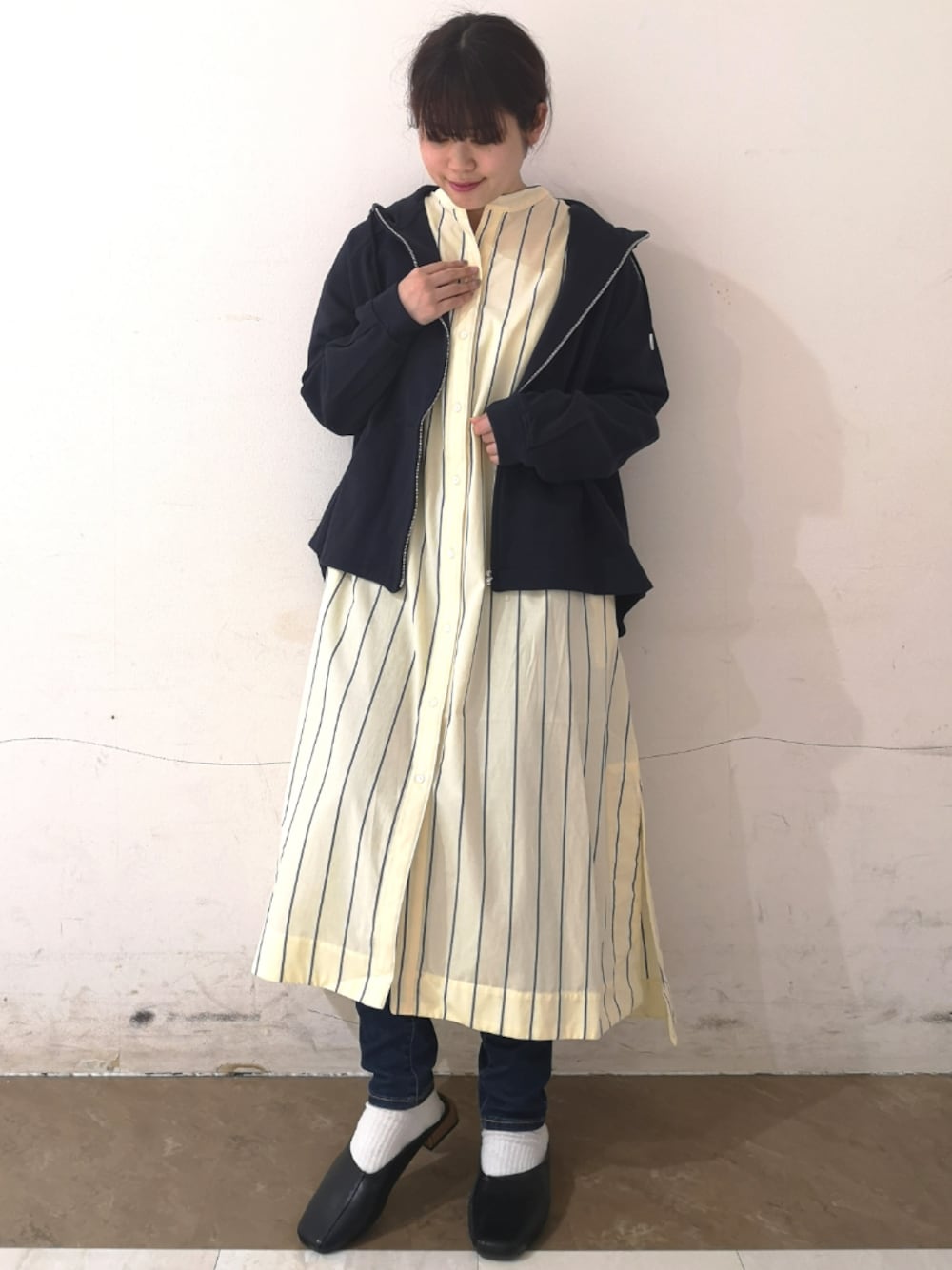 イエロー系のシャツワンピース、ブルー系のパーカー、ベージュ系のトップスを着用したレディースの春コーディネートの1枚目の写真