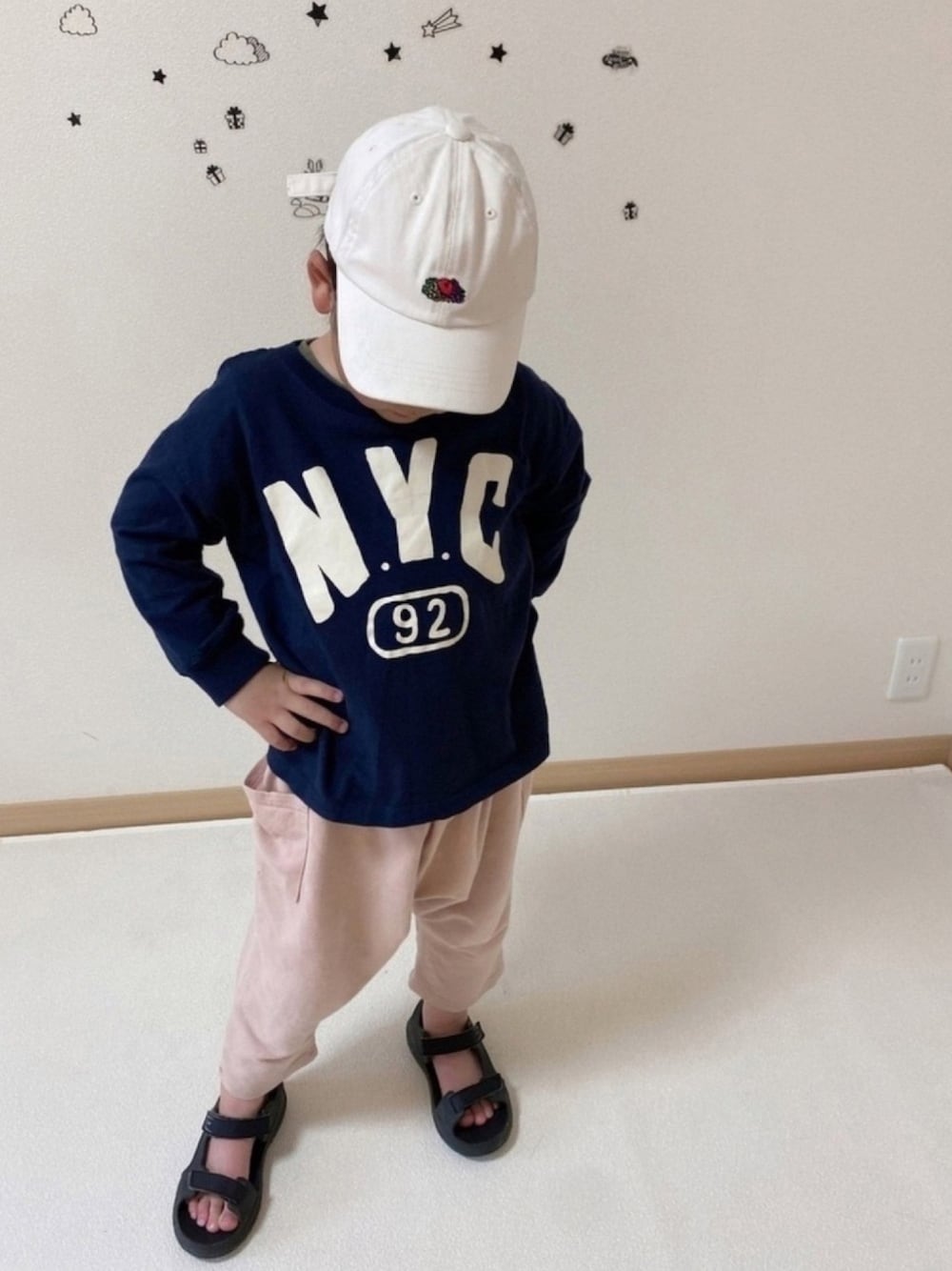 ピンク系のパンツ、ブルー系のTシャツ/カットソー、ホワイト系のキャップを着用したキッズの春コーディネートの1枚目の写真